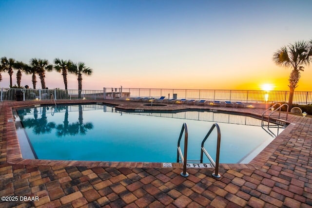 pool with a patio and fence