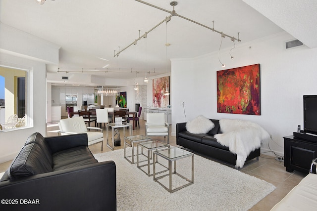 living area featuring tile patterned flooring, visible vents, rail lighting, and ornamental molding