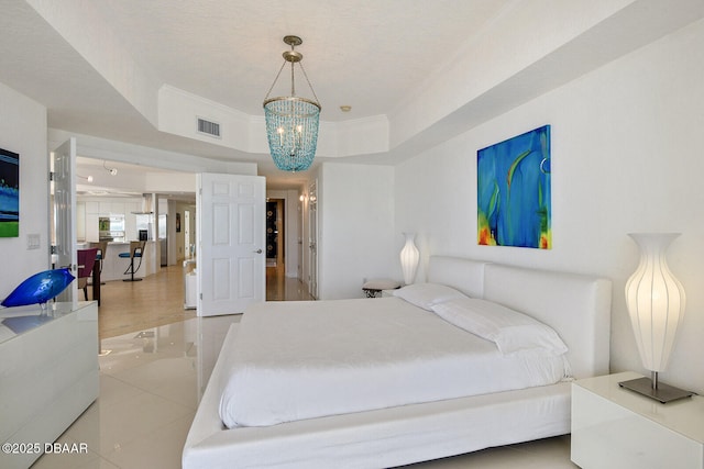 bedroom with visible vents, a raised ceiling, an inviting chandelier, and ornamental molding