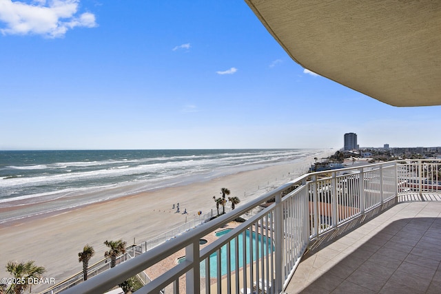 balcony featuring a water view and a beach view