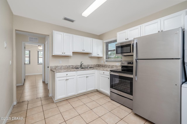 59 Cardinal Dr Unit A, Ormond Beach, FL 32176 - kitchen featuring stainless steel appliances, white cabinetry, light tile patterned flooring, and a ceiling fan