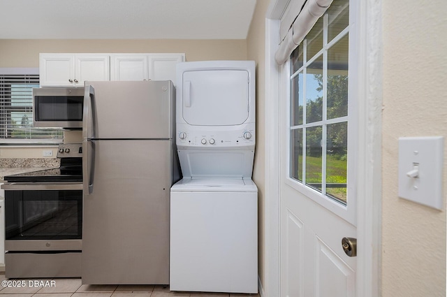 59 Cardinal Dr Unit A, Ormond Beach, FL 32176 - washroom with estacked washer and dryer and light tile patterned floors