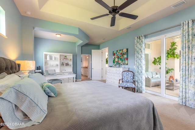 carpeted bedroom with a tray ceiling, visible vents, ceiling fan, and access to outside