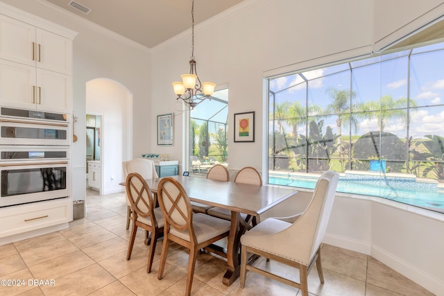 dining area featuring visible vents, ornamental molding, arched walkways, an inviting chandelier, and light tile patterned floors