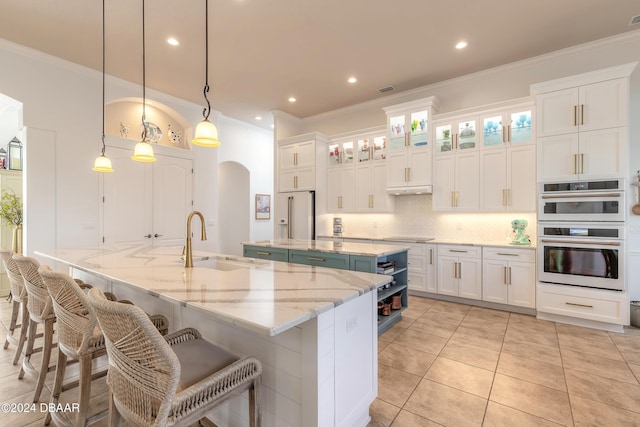 kitchen featuring a spacious island, a sink, white cabinetry, white double oven, and decorative backsplash