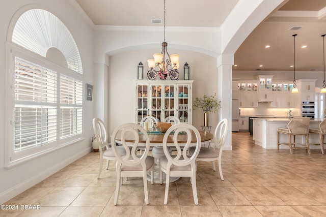 dining room with an inviting chandelier, light tile patterned floors, ornamental molding, baseboards, and visible vents