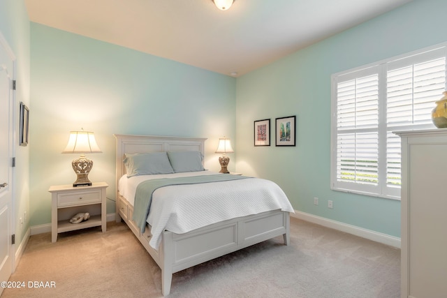 bedroom featuring light colored carpet and baseboards