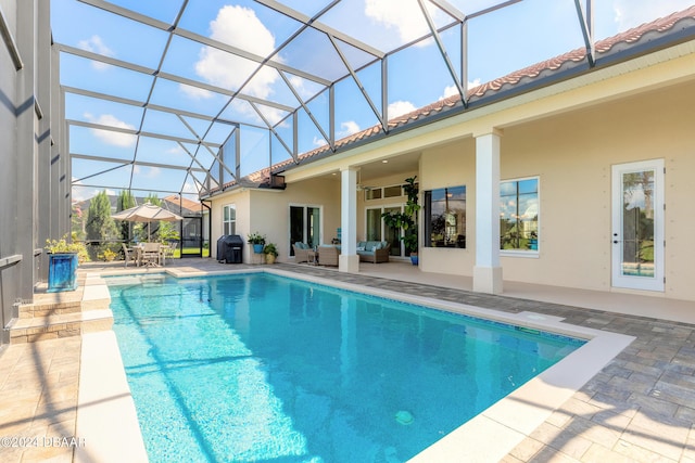 pool featuring an outdoor hangout area, glass enclosure, a ceiling fan, area for grilling, and a patio area