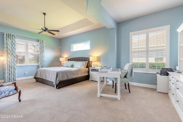 bedroom with light carpet, baseboards, and multiple windows