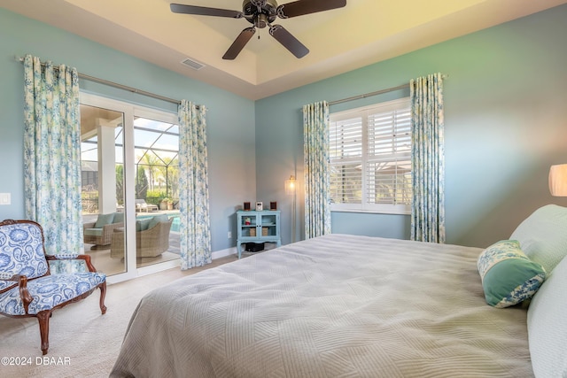 carpeted bedroom featuring multiple windows, visible vents, a ceiling fan, and access to outside