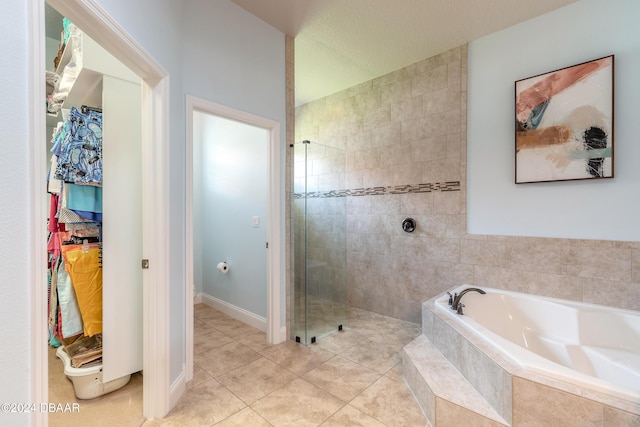 full bathroom with a bath, baseboards, a walk in closet, tiled shower, and tile patterned flooring