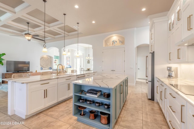 kitchen featuring a spacious island, open shelves, freestanding refrigerator, white cabinets, and arched walkways