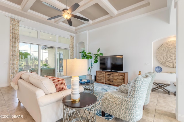 tiled living room featuring coffered ceiling, ornamental molding, a high ceiling, beamed ceiling, and ceiling fan