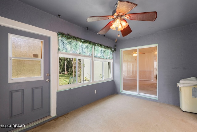 unfurnished sunroom featuring ceiling fan