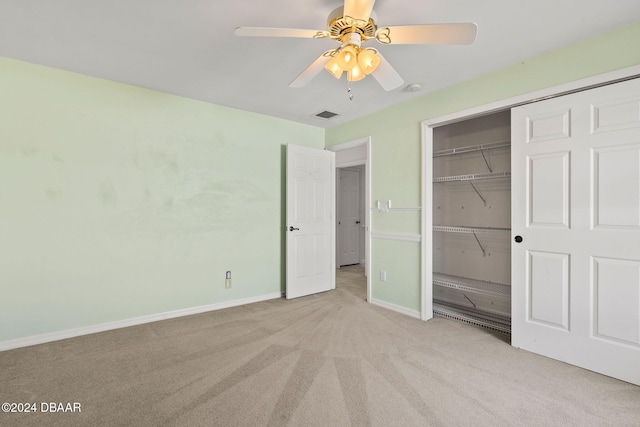 unfurnished bedroom with light carpet, ceiling fan, and a closet