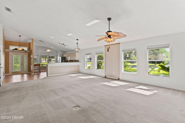 unfurnished living room with lofted ceiling, french doors, light colored carpet, and ceiling fan