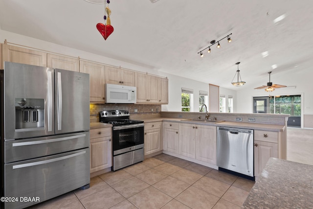 kitchen with appliances with stainless steel finishes, light tile patterned floors, pendant lighting, sink, and kitchen peninsula