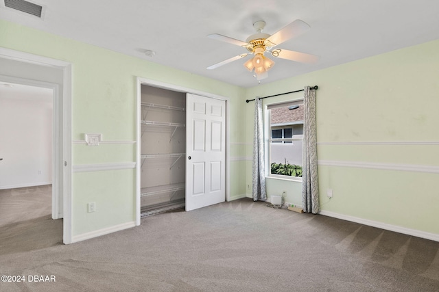 unfurnished bedroom featuring ceiling fan, a closet, and light colored carpet