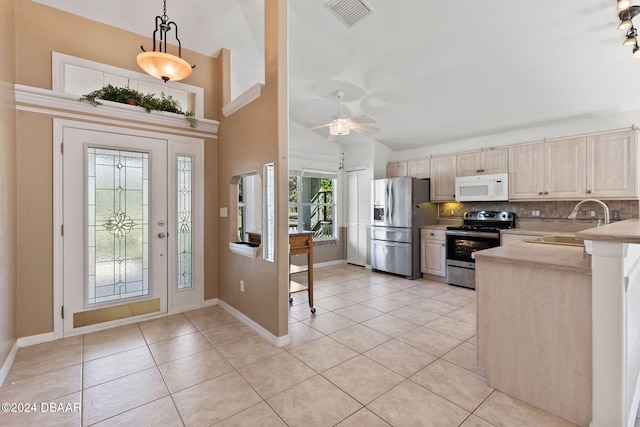 entryway with ceiling fan, high vaulted ceiling, light tile patterned floors, and sink