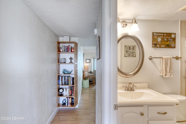 bathroom with wood-type flooring, a textured ceiling, and vanity