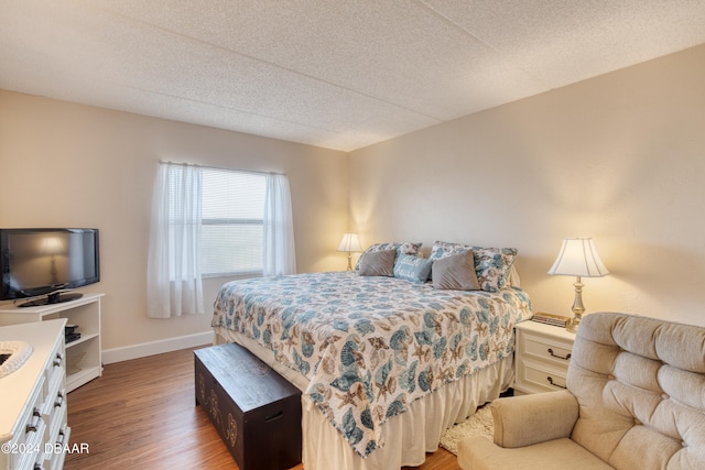 bedroom featuring wood-type flooring and a textured ceiling