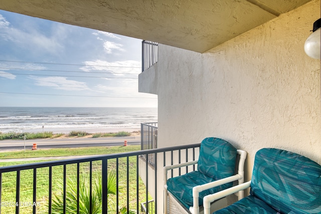 balcony featuring a water view and a beach view