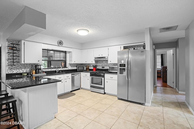 kitchen featuring white cabinets, a textured ceiling, stainless steel appliances, and sink