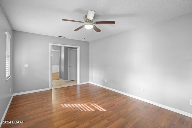 unfurnished bedroom with ceiling fan, a closet, a textured ceiling, and light hardwood / wood-style flooring