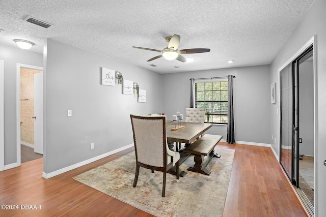 dining area featuring hardwood / wood-style floors, ceiling fan, and a textured ceiling