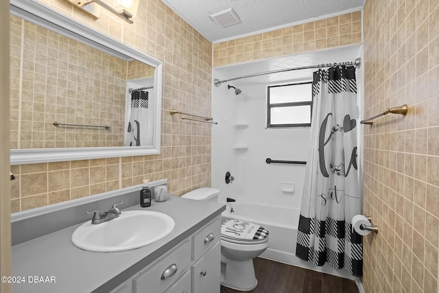 full bathroom with a textured ceiling, shower / bath combo with shower curtain, tile walls, and hardwood / wood-style flooring