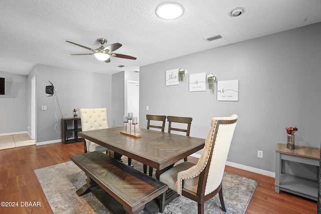 dining room with a textured ceiling, ceiling fan, and dark hardwood / wood-style floors