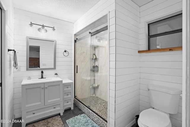 bathroom with walk in shower, vanity, a textured ceiling, wooden walls, and toilet