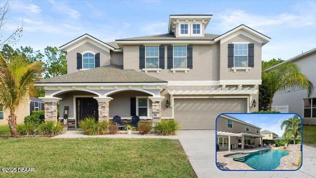 view of front of home with a front yard, a garage, and a pergola