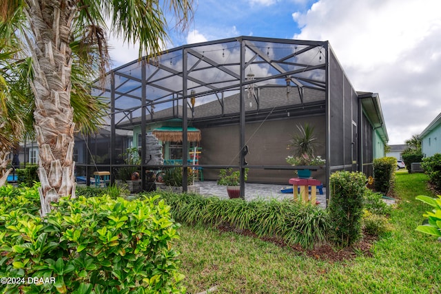 back of house featuring a patio and glass enclosure