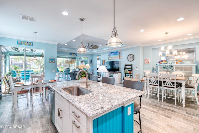 kitchen featuring white cabinetry, sink, light hardwood / wood-style floors, and a kitchen island with sink