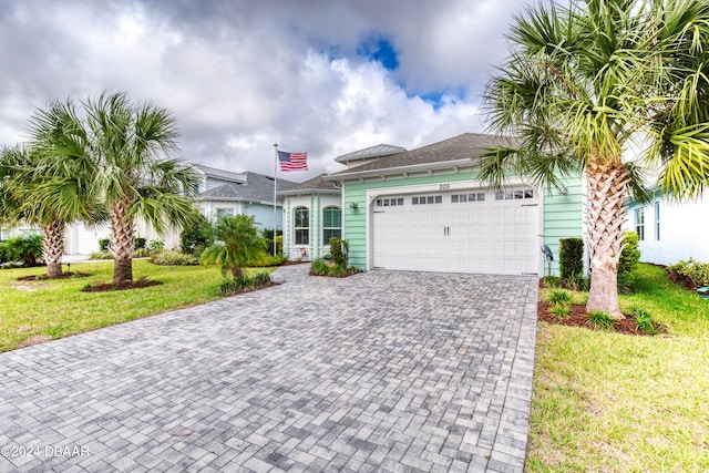 view of front of house with a garage and a front lawn