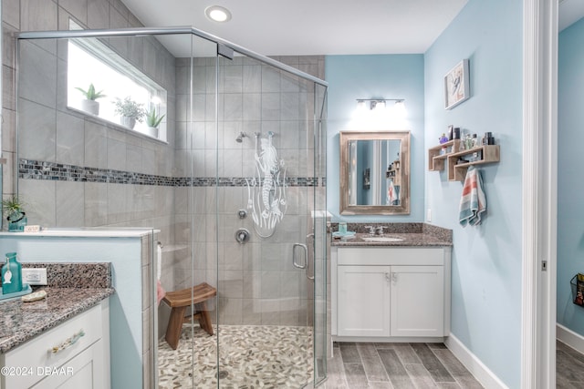 bathroom with vanity, wood-type flooring, and a shower with door