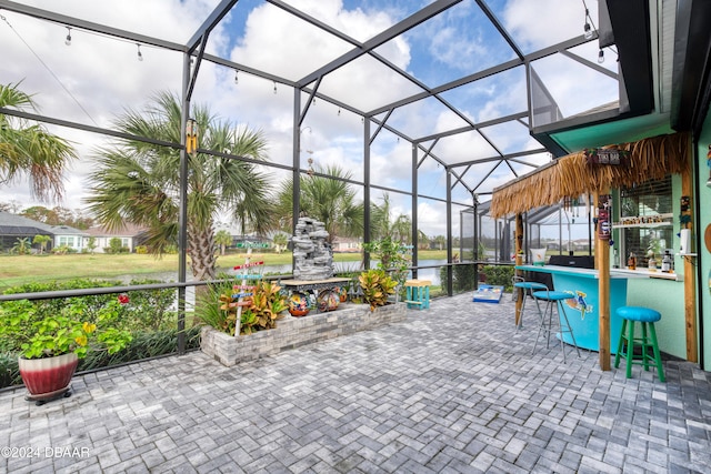 view of patio / terrace with a lanai and a water view