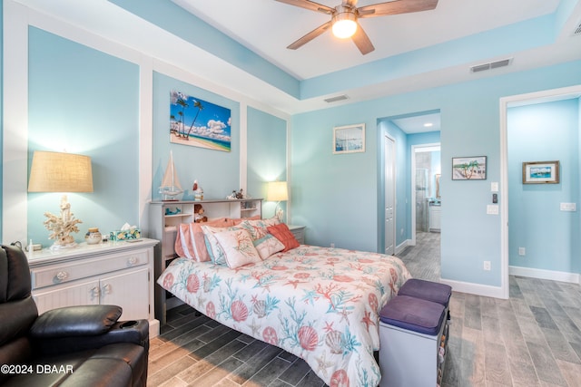 bedroom with hardwood / wood-style floors, ceiling fan, and connected bathroom