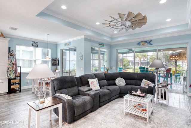 living room with ornamental molding, light hardwood / wood-style flooring, ceiling fan, and plenty of natural light