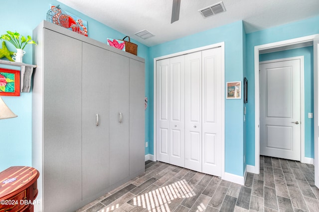 unfurnished bedroom featuring ceiling fan, dark hardwood / wood-style floors, a textured ceiling, and a closet