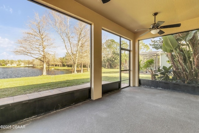 unfurnished sunroom featuring ceiling fan and a water view