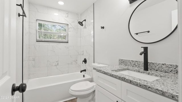 full bathroom with vanity, tiled shower / bath combo, and toilet