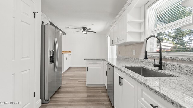 1801 James St, South Daytona, FL 32119 - kitchen featuring stainless steel appliances, a sink, ceiling fan, light wood-type flooring, and white cabinets