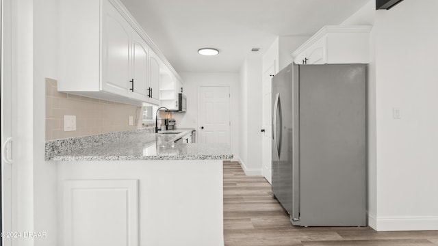 1801 James St, South Daytona, FL 32119 - kitchen featuring freestanding refrigerator, a sink, white cabinets, and baseboards