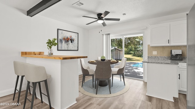 1801 James St, South Daytona, FL 32119 - dining space with light wood finished floors, a ceiling fan, baseboards, and a textured ceiling