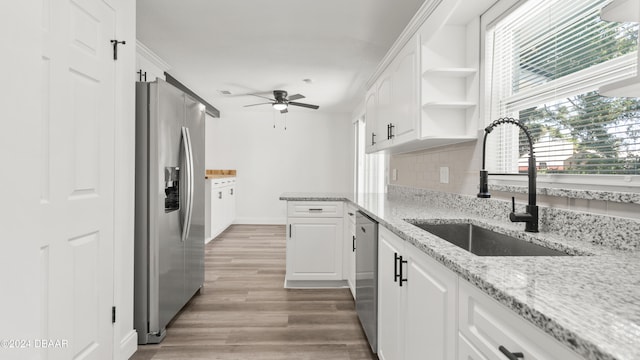 kitchen featuring light stone counters, hardwood / wood-style flooring, sink, white cabinetry, and appliances with stainless steel finishes