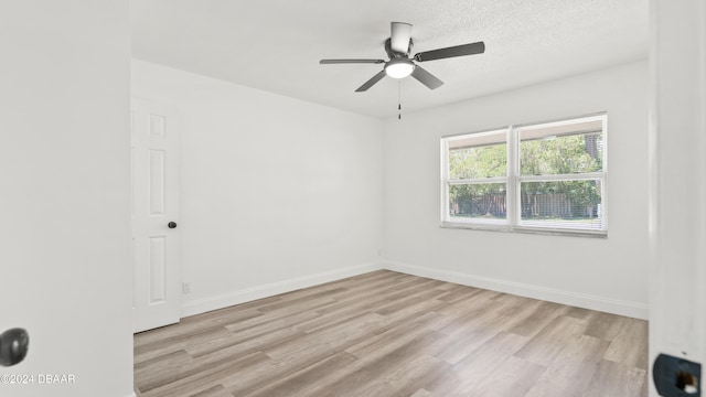 spare room with ceiling fan, a textured ceiling, and light hardwood / wood-style floors