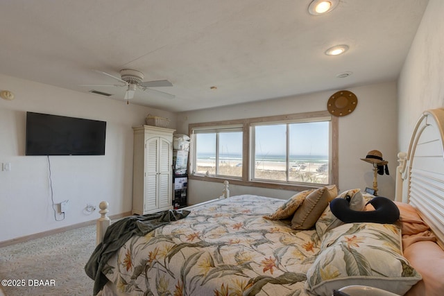 carpeted bedroom with ceiling fan, a view of the beach, a water view, visible vents, and baseboards