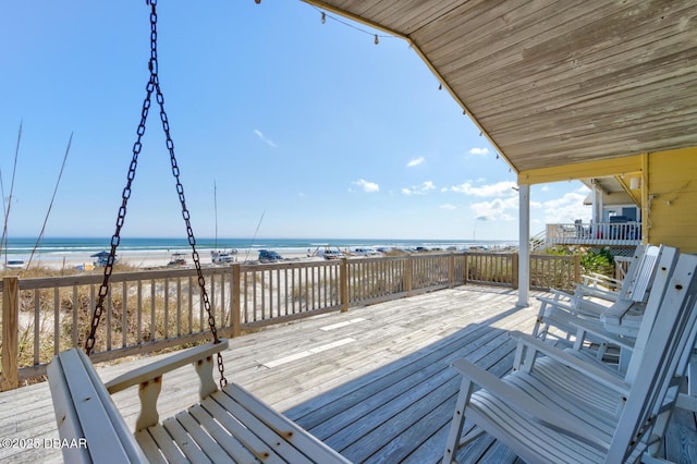 deck featuring a view of the beach and a water view